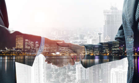 Close-up of the handshake of businessmen. Against the backdrop of the cityscapeの写真素材
