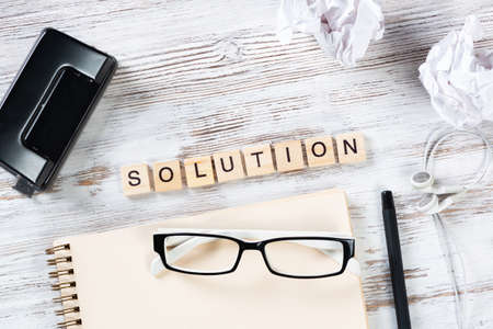 Business solution concept with letters on cubes. Still life of office workspace. Flat lay vintage...