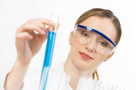 Pharmacology science laboratory research. Female scientist in protective goggles holding test tube...