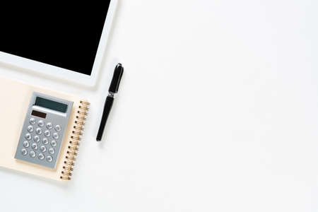 Still life of accountant workspace with office accessories. Flat lay white desk with tablet...