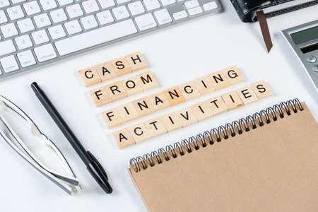 Cash from financing activities concept with letters. Still life of office workplace with supplies....