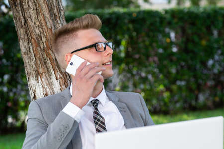 businessman speaks on the phone in the park. work out of the office