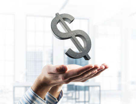 Close of businessman hand showing in palm stone dollar sign. Mixed mediaの写真素材