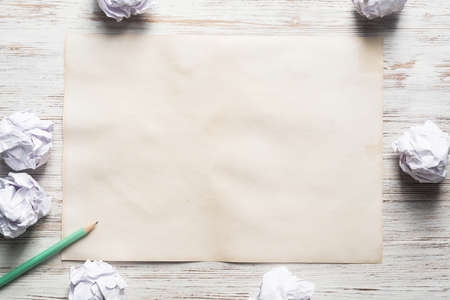 Close up of sheet of white paper and pencil on wooden table