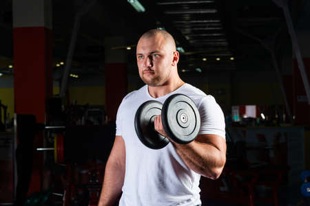 Male bodybuilder engaged with dumbbells in the gym. Healthy lifestyle