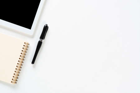 Top view of blogger workplace. Spiral notepad, pen and tablet computer on white surface. Education, creativity and innovation concept with copy space. Digital technology in modern business.の写真素材