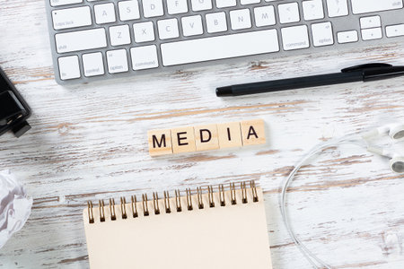 Social media concept with letters on cubes. Flat lay vintage wooden desk with computer keyboard, pen and spiral notebook. Online connection and communication. Still life of blogger workplace.の写真素材