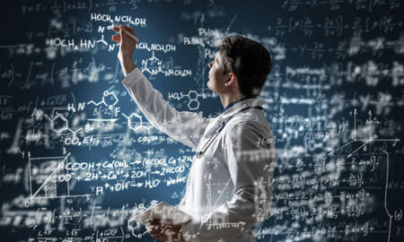 young scientist works with scientific formulas. mixed mediaの写真素材