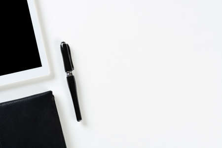 Still life of modern office workspace with supplies. Flat lay white desk with black leather wallet...