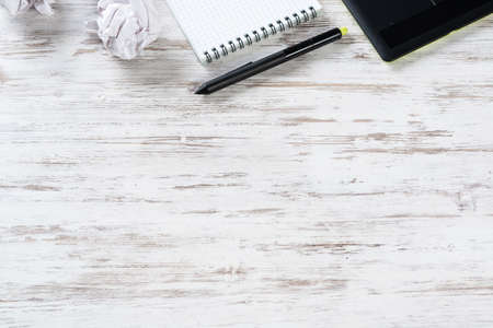 Still life of modern office workspace with copy space. Flat lay composition with graphic tablet and spiral notepad on wooden surface. Time management and day planning. Corporate business workplaceの写真素材