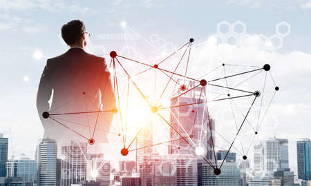 Double exposure of elegant businessman and modern busines city with towers and skyscrapers