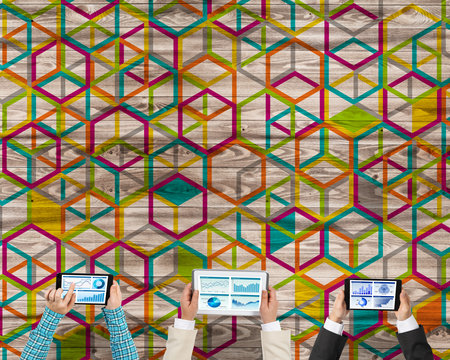 Group of three people with devices in hands working together as symbol of networking and communicationの写真素材
