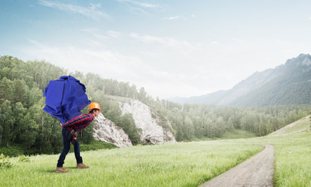 Builder man carrying paper ball on his backの写真素材
