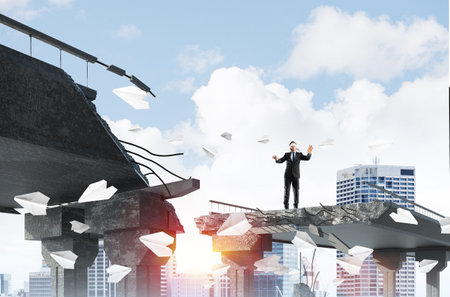 Businessman walking blindfolded among flying paper planes on concrete bridge with huge gap as symbol of hidden threats and risks. Cityscape and sunlight on background. 3D rendering.の写真素材