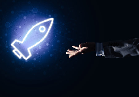 Rocket glowing icon and businessman hand on dark backgroundの写真素材