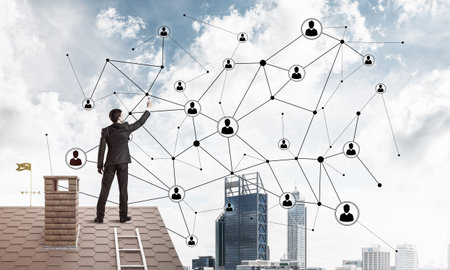 Young man standing with back on roof and drawing connection lines. Mixed mediaの写真素材
