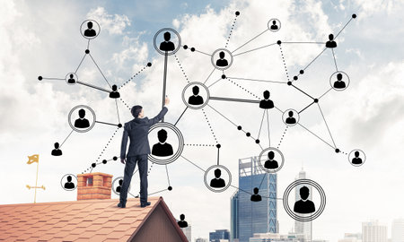 Young man standing with back on roof and drawing connection lines. Mixed mediaの写真素材