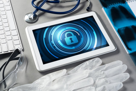 Doctors workplace with white tablet stethoscope and maskの写真素材