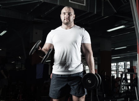 Male bodybuilder engaged with dumbbells in the gym. Healthy lifestyleの写真素材
