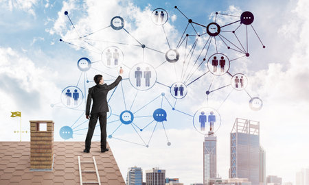 Young man standing with back on roof and drawing connection lines. Mixed mediaの写真素材