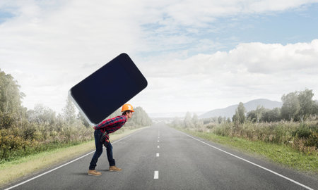 Man engineer carrying on back big smartphoneの写真素材