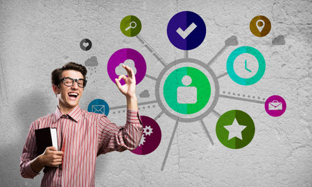 Funny guy with book and color application icons at backgroundの写真素材