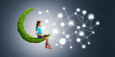 Cute kid girl sitting on green moon and social connection conceptの写真素材