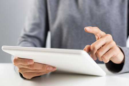 Woman using tablet computer for financial data analysis. Online shopping and blogging. Close-up of female hands touching screen of tablet device. Mobile smart device in business processesの写真素材