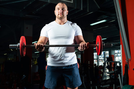 Man in the gym lifts the barbell. bodybuilding and healthy lifestyleの写真素材