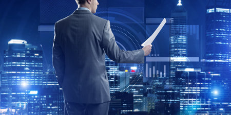 Rear view of businessman against virtual panel interface holding papers in handの写真素材