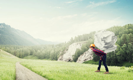Builder man carrying paper ball on his backの写真素材