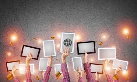 Set of tablets in female hands and glass bulbs fly aroundの写真素材
