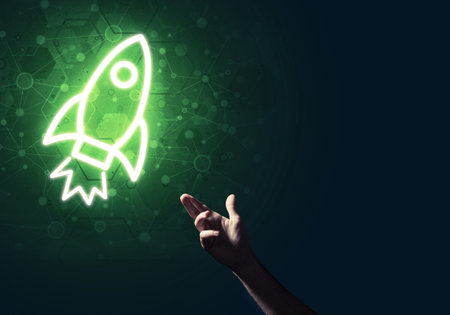 Rocket glowing icon and man hand on dark backgroundの写真素材