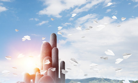 Image of high and huge stone columns located outdoors among flying paper planes with beautiful landscape on background. Wallpaper, backdrop with copyspace.の写真素材