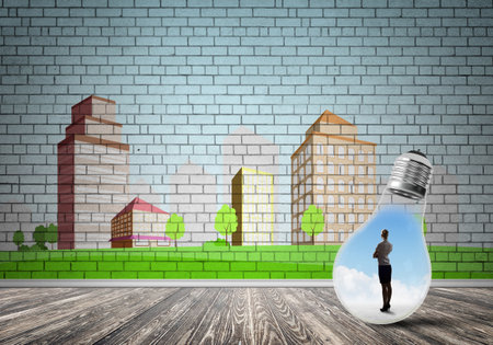 Businesswoman inside light bulb against city drawn conceptの写真素材