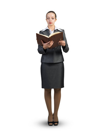 A businesswoman in a business suit stands with an open diary in her hands. On a white backgroundの写真素材