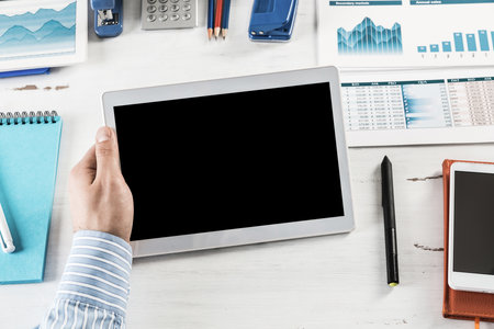 close-up of mens hands with a computer tablet. Businessman works in the officeの写真素材