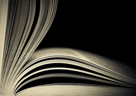 Close-up of opened book pages against black background. Space for text. Shallow DOF.の写真素材