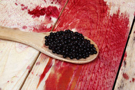 Therapeutic elderberry fruit on a wooden spoonの写真素材
