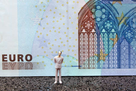 Businessman miniature figure on money backgroundの写真素材