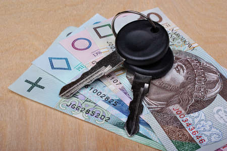 Car keys and money on the tableの写真素材