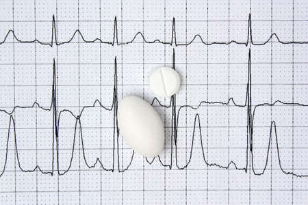 Pills on a background of electrocardiogram ECG cardiology disease