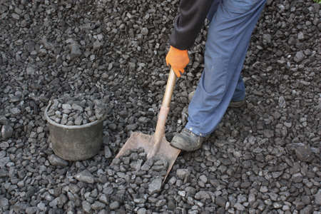 Miner is picking up coal with shovelの写真素材