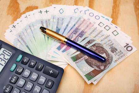 Polish money and calculator on a wooden tableの写真素材