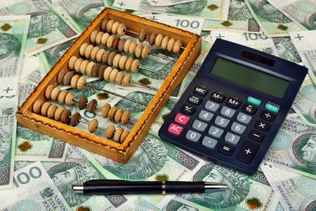 Polish money, pen, abacus on the banknote backgroundの写真素材