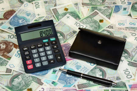 Polish money, calculator, pen and wallet on money backgroundの写真素材