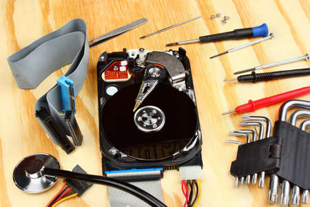 Opened hard disk with a sthetoscope on a wooden table