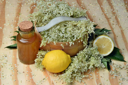 Elderflower syrup with lemon on wooden background and fresh flowerの写真素材