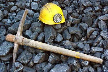 Pickaxe, mining helmet in the background heap of coalの写真素材