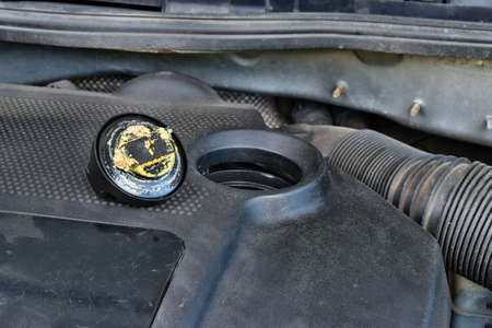 The thick, greasy yellow motor oil under oil cap as signs and symptom of a blown head gasket. Broken...